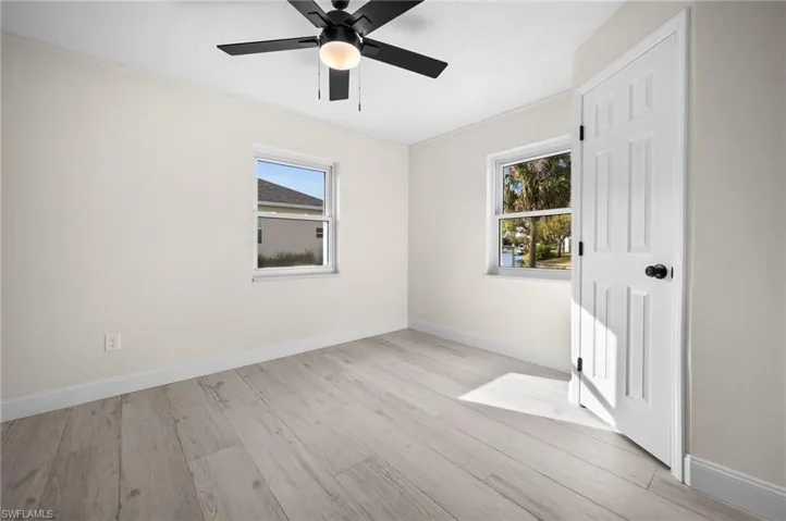 Spare room with a ceiling fan, baseboards, and wood finished floors