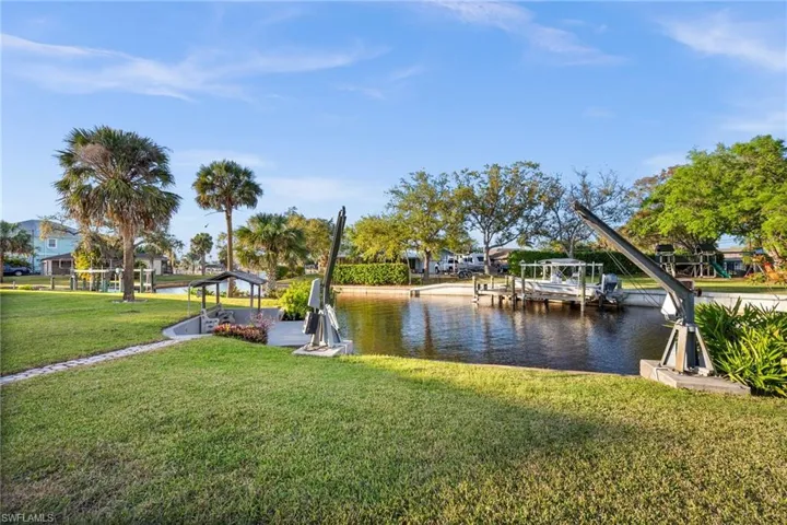 Dock area with a water view and a lawn
