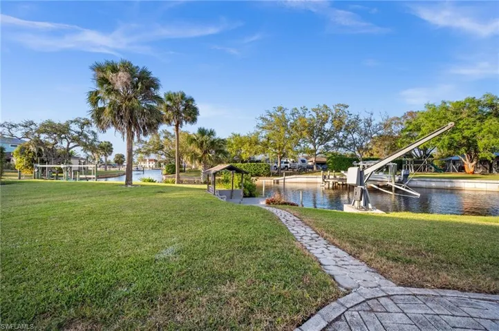 Surrounding community with a water view and a yard