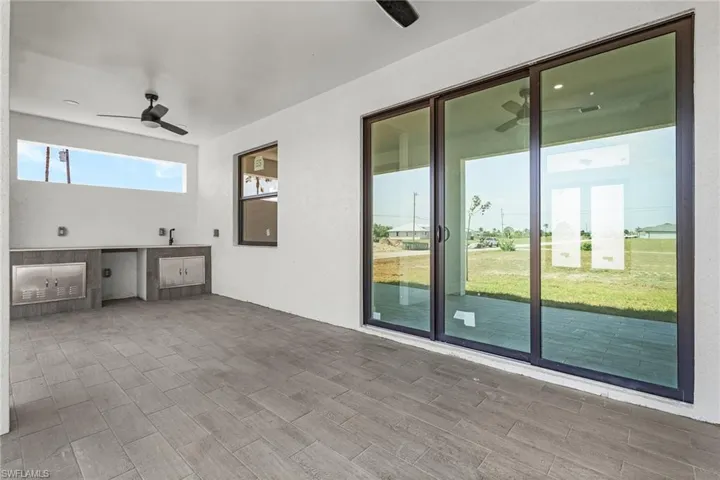 View of patio with exterior kitchen and ceiling fan