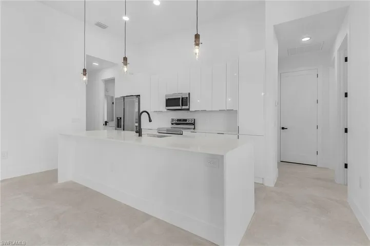 Kitchen with white cabinetry, stainless steel appliances, a sink, visible vents, and modern cabinets