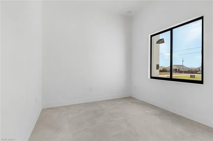 Empty room featuring concrete flooring and baseboards