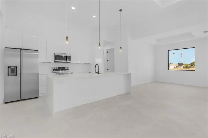 Kitchen with white cabinetry, light countertops, modern cabinets, and appliances with stainless steel finishes