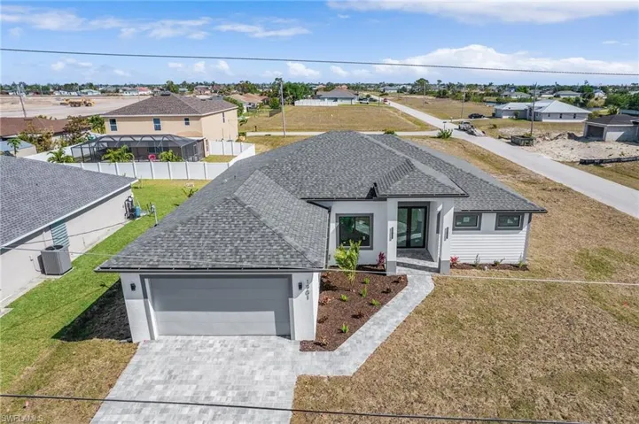 Single story home with decorative driveway, stucco siding, roof with shingles, and an attached garage