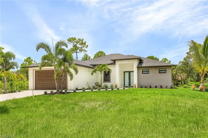 View of front of property with a garage and a front yard