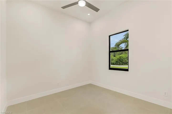 Unfurnished room with light tile patterned floors and ceiling fan