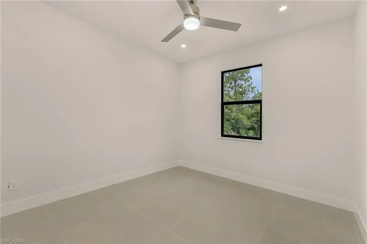 Unfurnished room with light tile patterned floors and ceiling fan