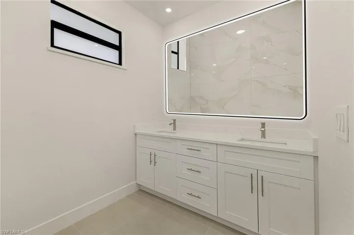 Bathroom with dual vanity and tile patterned floors