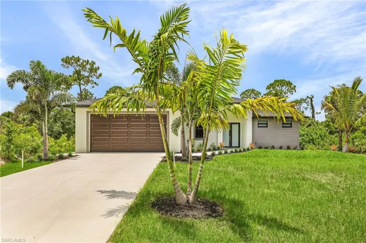 View of front of house with a garage and a front lawn