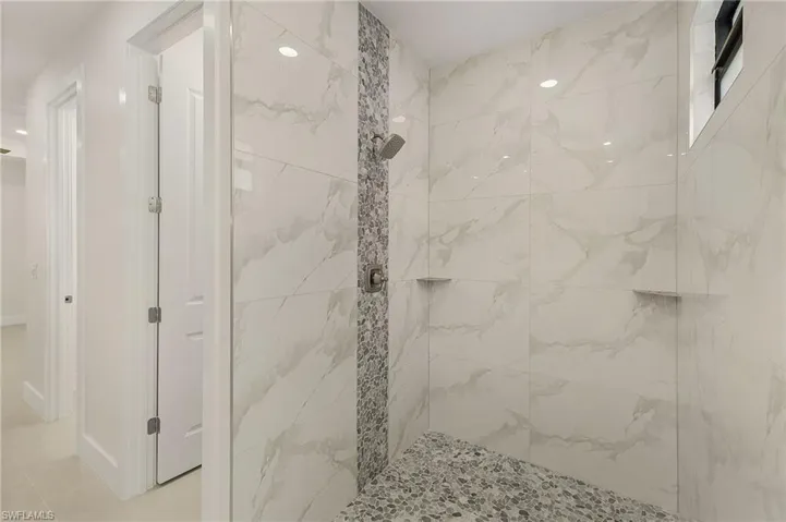 Bathroom with tile patterned floors and a tile shower
