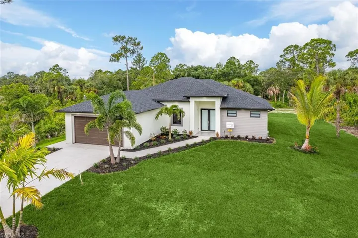 View of front of house with a garage and a front lawn