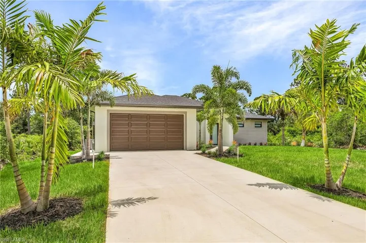 View of front of property with a garage and a front yard