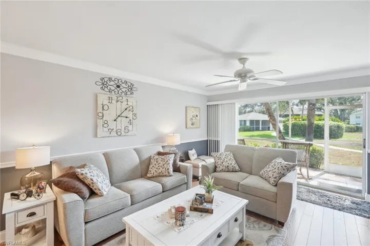 Living room with ceiling fan, light hardwood / wood-style flooring, and crown molding
