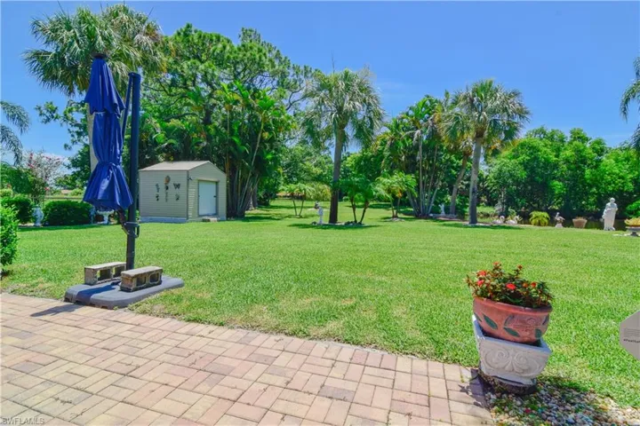 View of yard with a patio area, an outdoor structure, and a garage