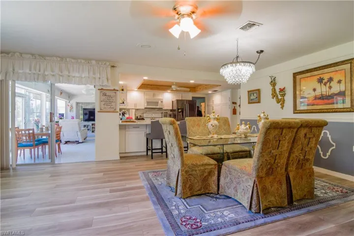 Dining area featuring light hardwood / wood-style flooring and ceiling fan with notable chandelier