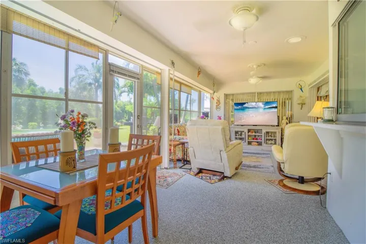 Carpeted dining room featuring ceiling fan