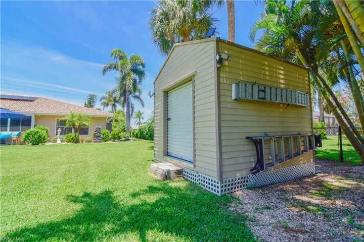 View of outdoor structure with a garage and a yard