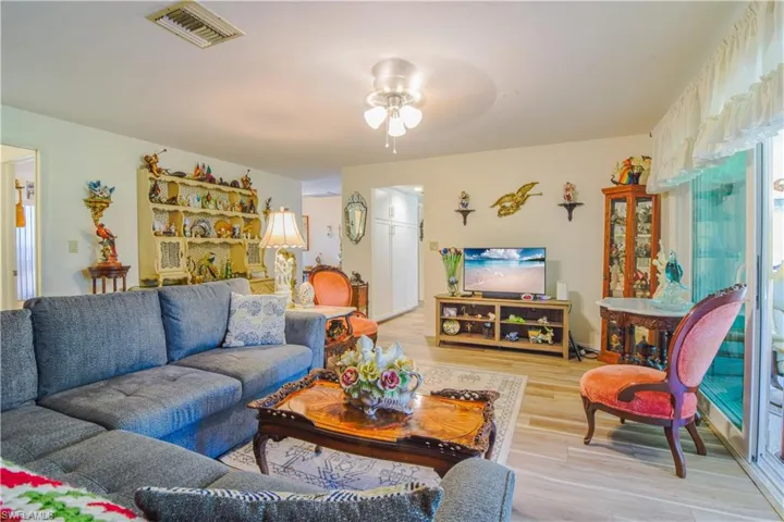 Living room with ceiling fan and light hardwood / wood-style floors