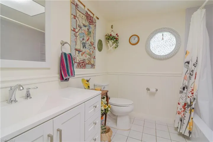 Full bathroom with tile flooring, shower / tub combo, toilet, and vanity