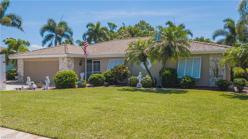 View of front of house featuring a garage and a front lawn
