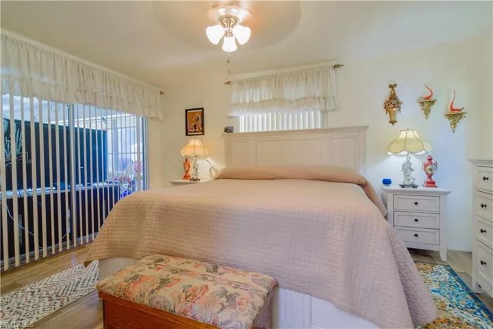 Bedroom featuring hardwood / wood-style flooring, multiple windows, and ceiling fan