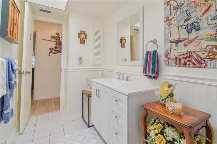 Bathroom featuring vanity with extensive cabinet space and tile floors