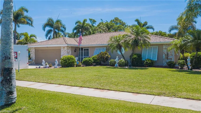 Single story home featuring a garage and a front lawn