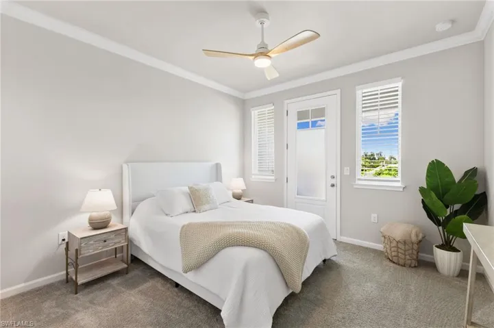 Carpeted bedroom with crown molding and ceiling fan