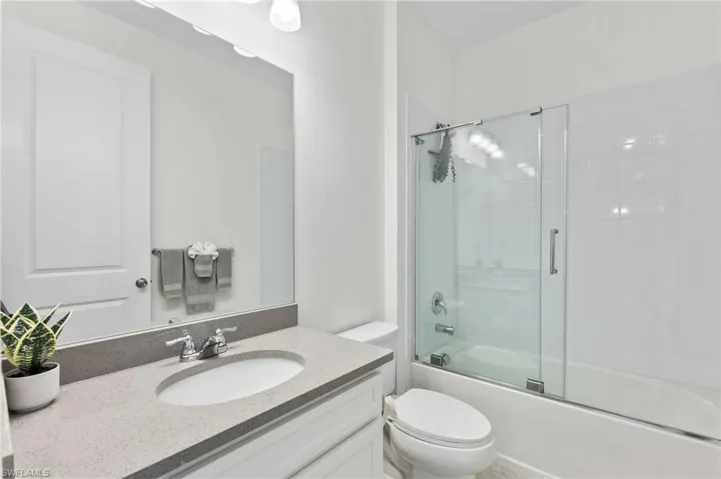 Full bathroom featuring bath / shower combo with glass door and vanity