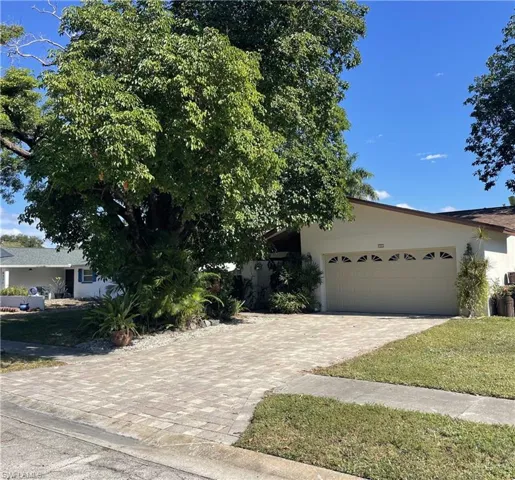 Obstructed view of property with stucco siding, driveway, and an attached garage