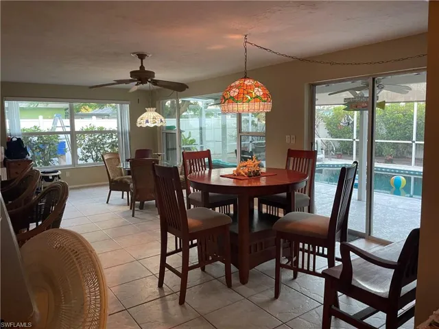 Dining area with ceiling fan, plenty of natural light, and light tile patterned flooring