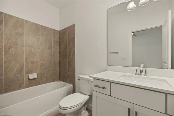 Full bathroom featuring vanity, toilet, and tiled shower / bath