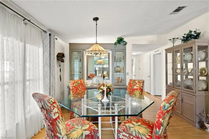 Dining room with light hardwood / wood-style flooring and a textured ceiling