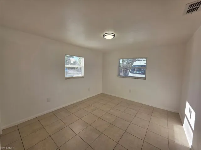 Unfurnished room featuring light tile patterned floors and baseboards