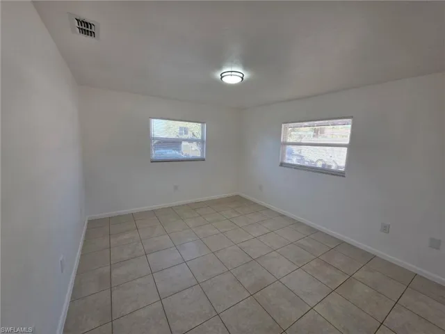 Unfurnished room with light tile patterned floors and baseboards