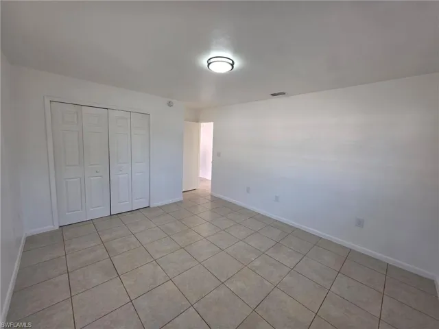 Unfurnished bedroom with light tile patterned floors and a closet