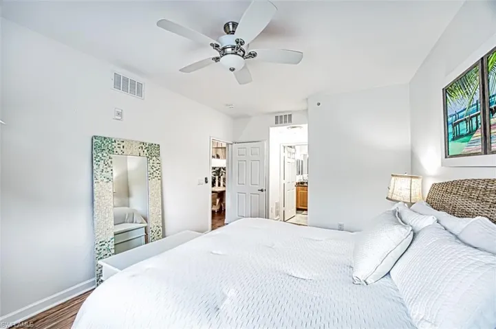 Bedroom featuring ensuite bathroom, wood-type flooring, and ceiling fan