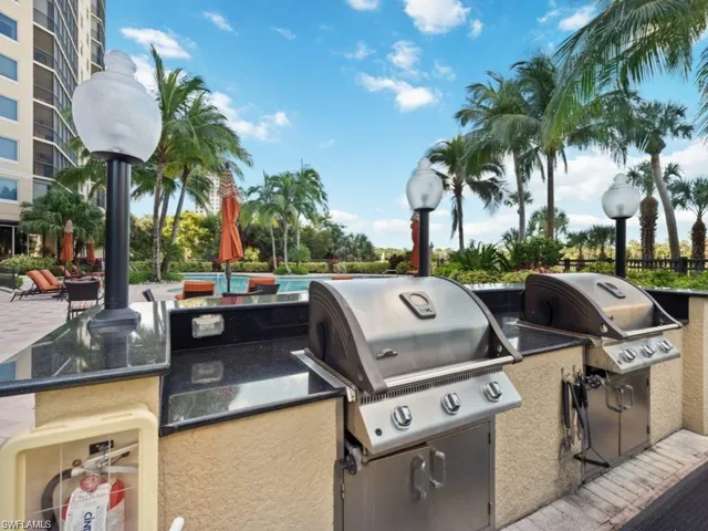 Poolside gas grilling stations, lighted at night.
