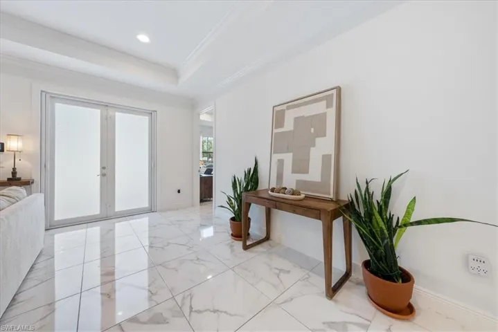 Entryway featuring light marble finish floors, french doors, crown molding, baseboards, and recessed lighting