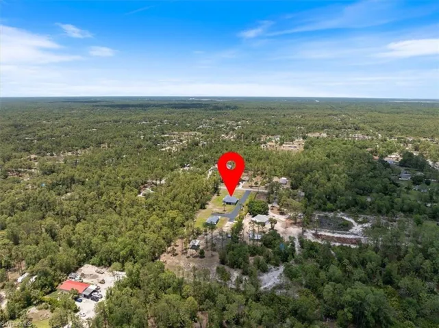 Aerial view of property's location with fenced in acreage