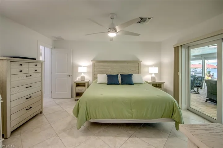 Bedroom with access to outside, light tile patterned floors, and ceiling fan