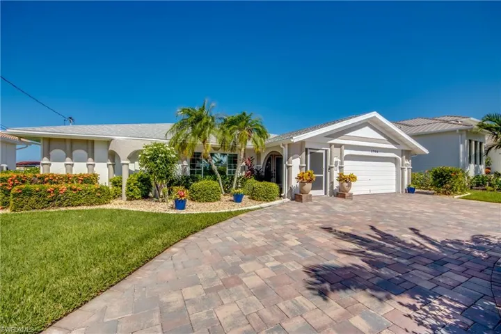 Ranch-style house featuring a garage and a front lawn
