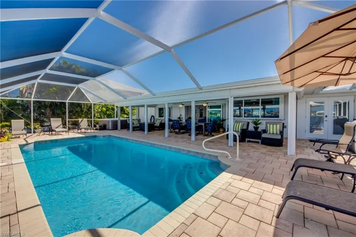 View of swimming pool featuring french doors, a lanai, and a patio