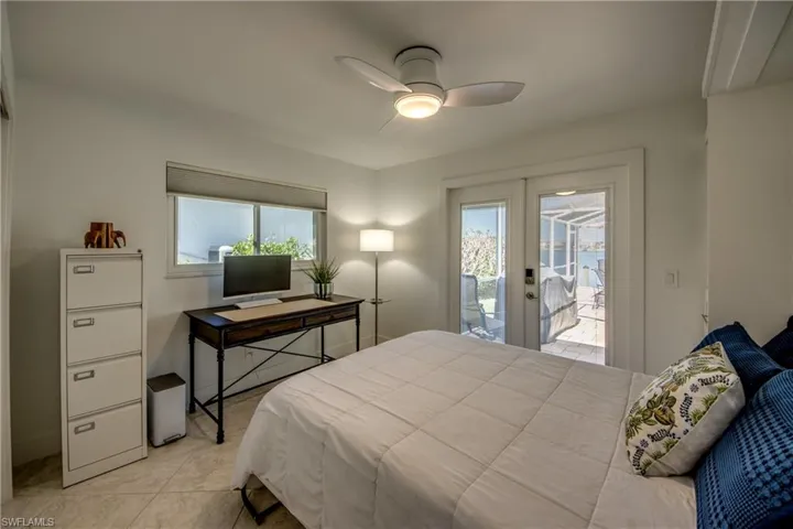 Tiled bedroom with access to exterior, ceiling fan, french doors, and multiple windows