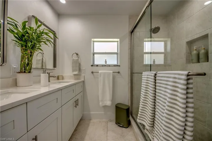 Bathroom featuring vanity, an enclosed shower, and tile patterned floors