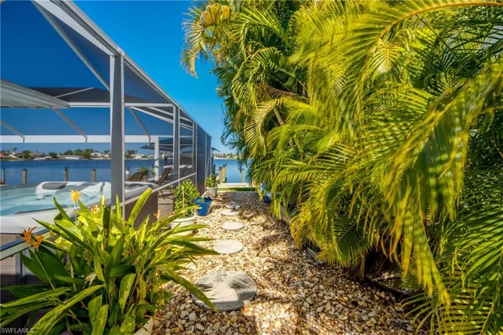 View of yard with a water view and glass enclosure