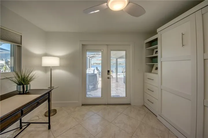 Entryway with ceiling fan, light tile patterned floors, and french doors