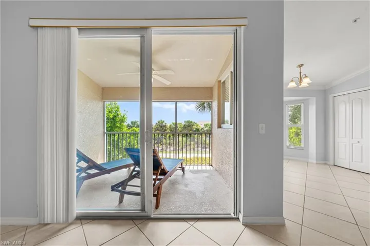 Screened balcony with a ceiling fan, offering outdoor living space