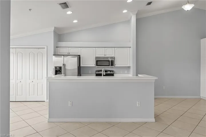 Kitchen featuring white cabinetry, stainless steel appliances, and a breakfast bar