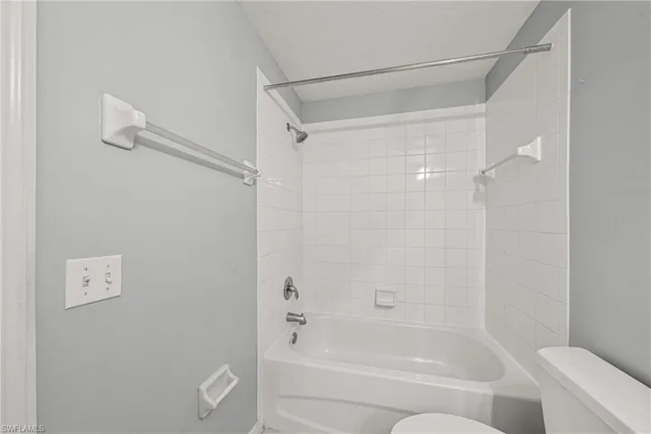 Bathtub and shower combination featuring white subway tile surround